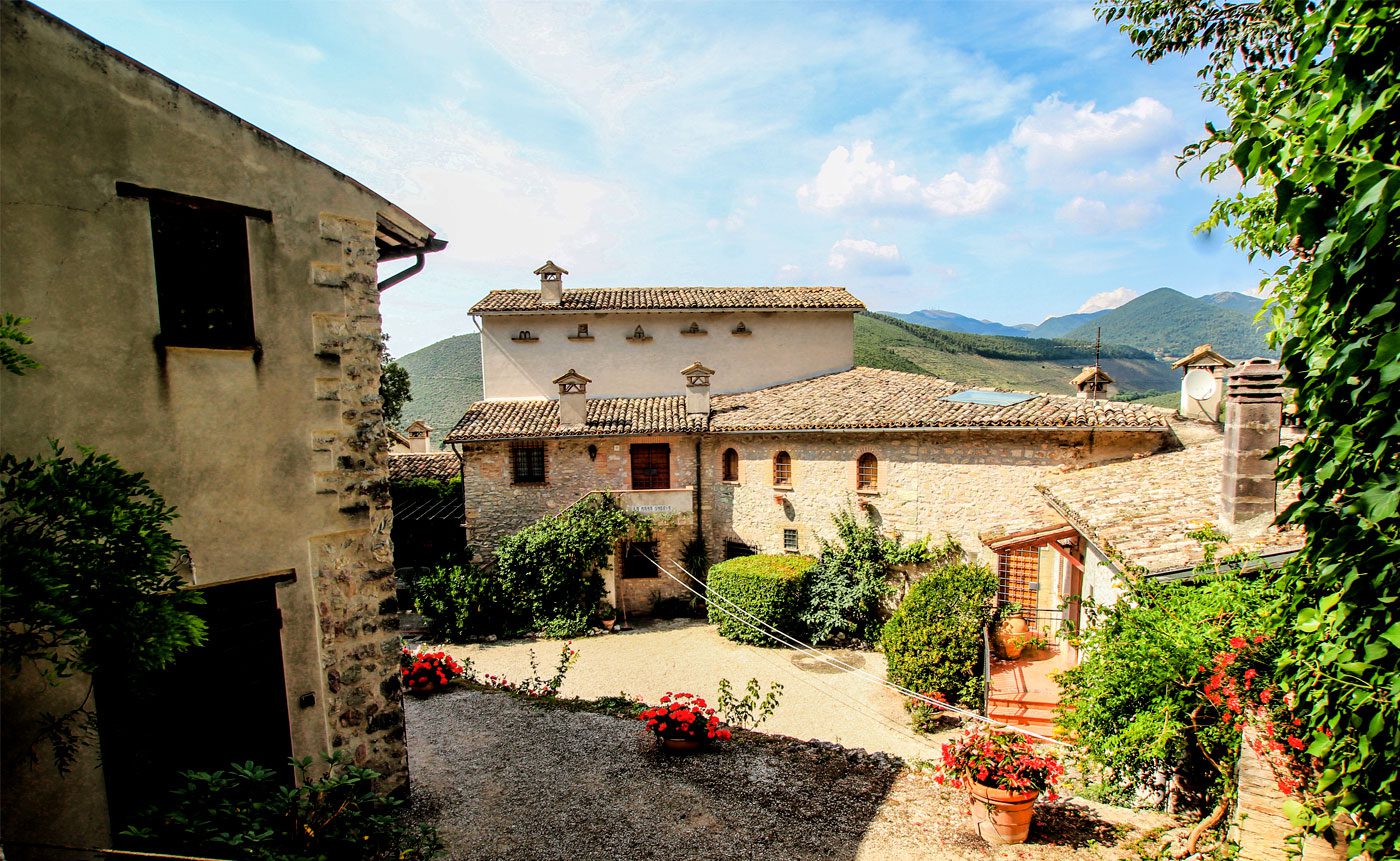 A stone building with a garden in front of it.