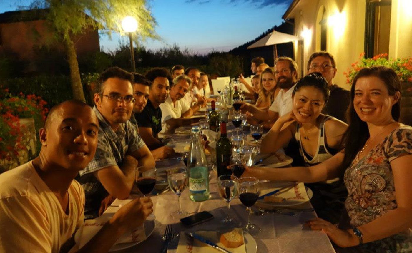 A group of people sitting around a table at night.