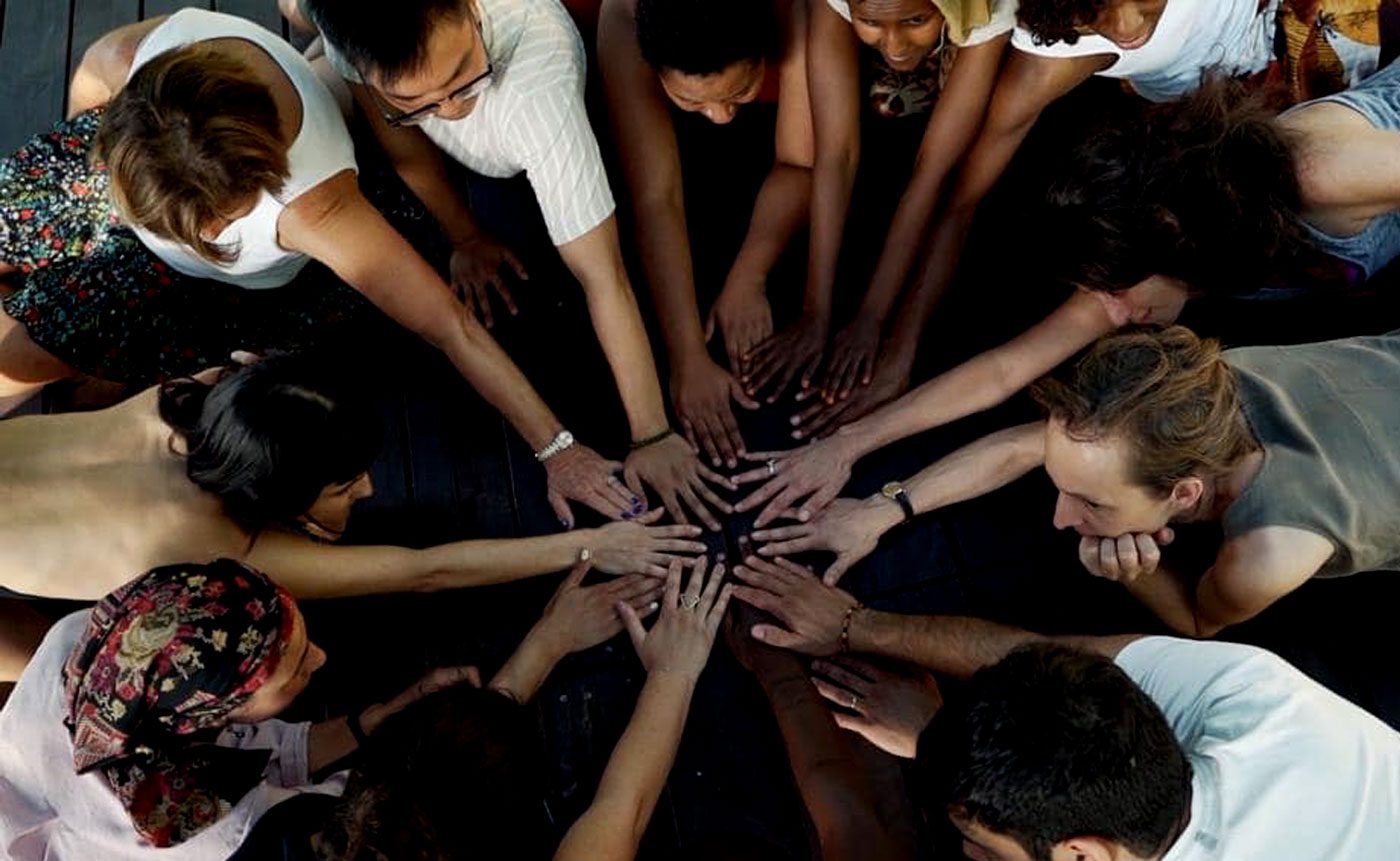 A group of people making a circle with their hands.