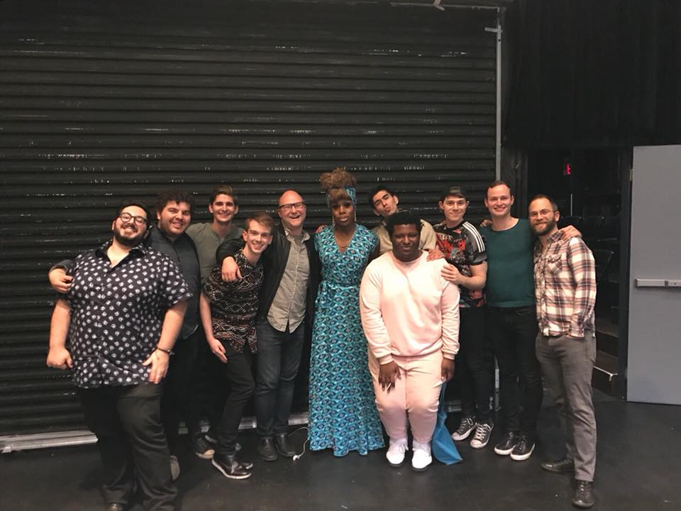 A group of people posing for a photo in a theater.