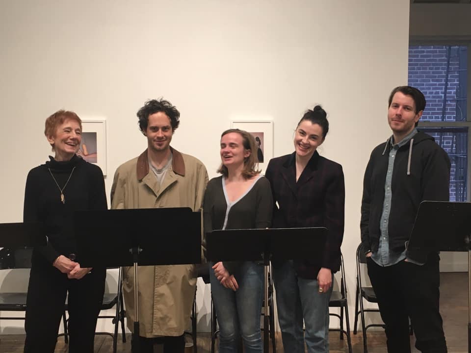 A group of people standing next to each other in an art gallery.