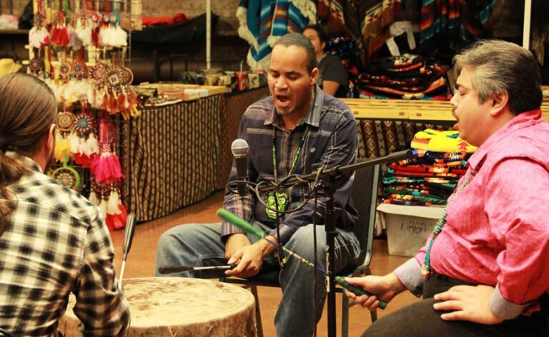 A group of people sitting around a drum in a store.