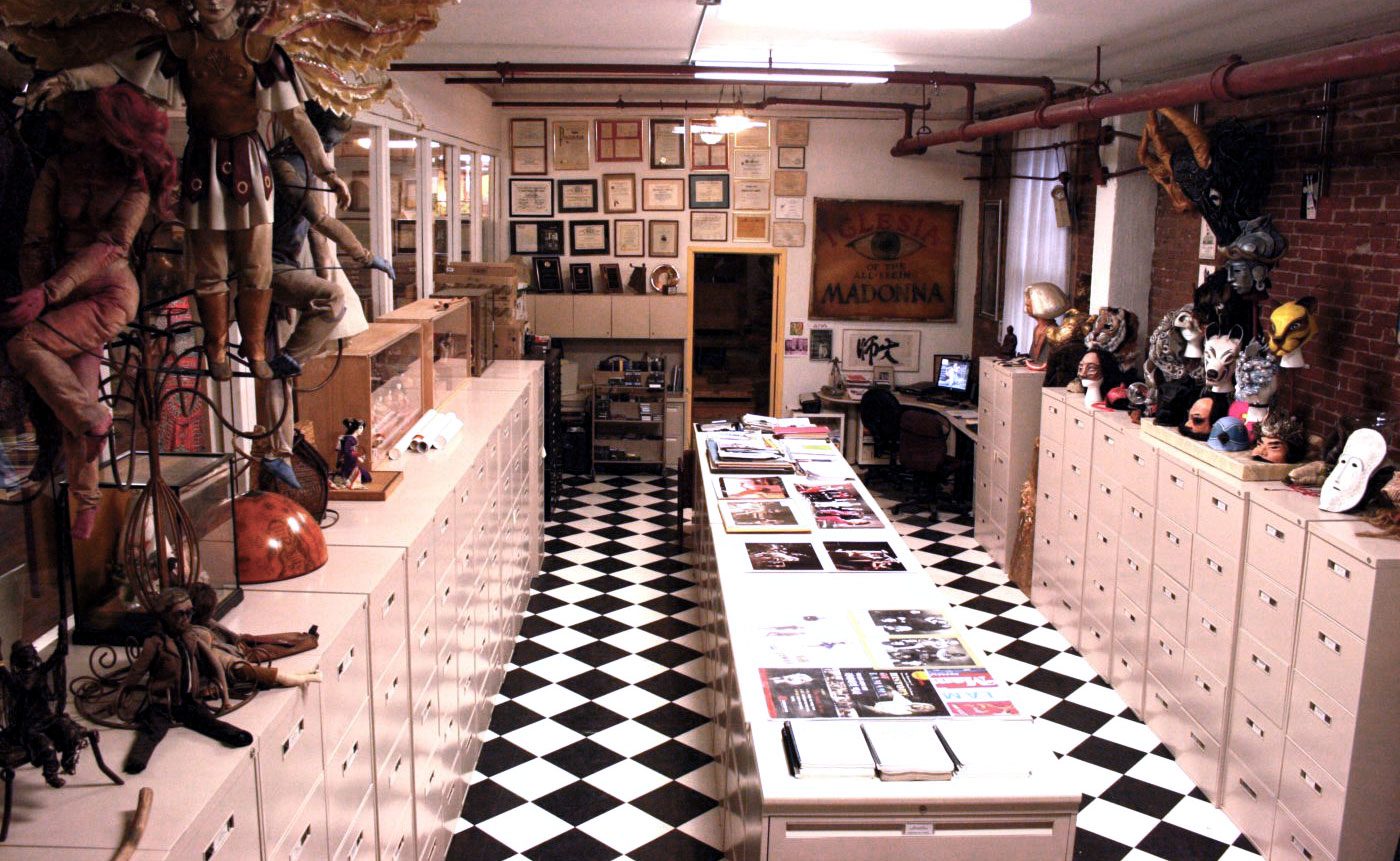 A black and white checkered floor in a room with a lot of items.