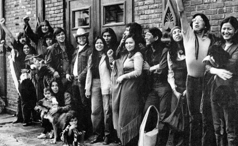 A group of people posing in front of a building.