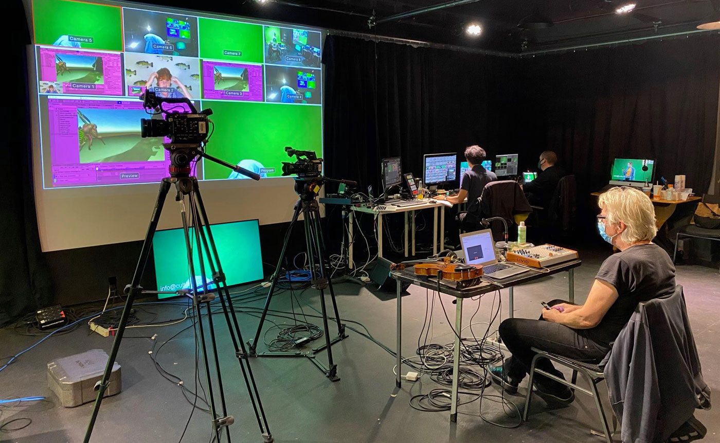 A group of people sitting in front of a green screen.