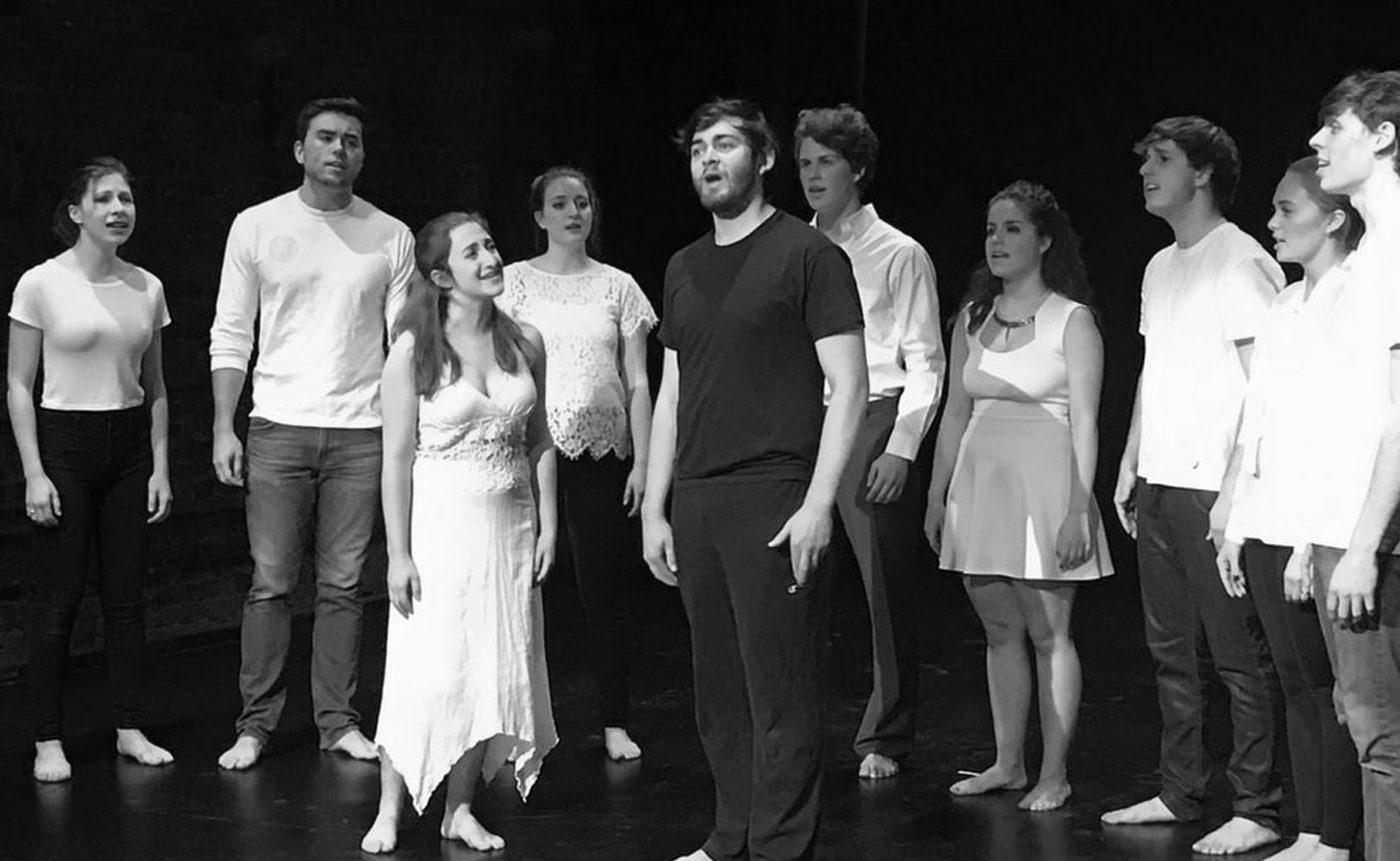 A black and white photo of a group of people standing on stage.