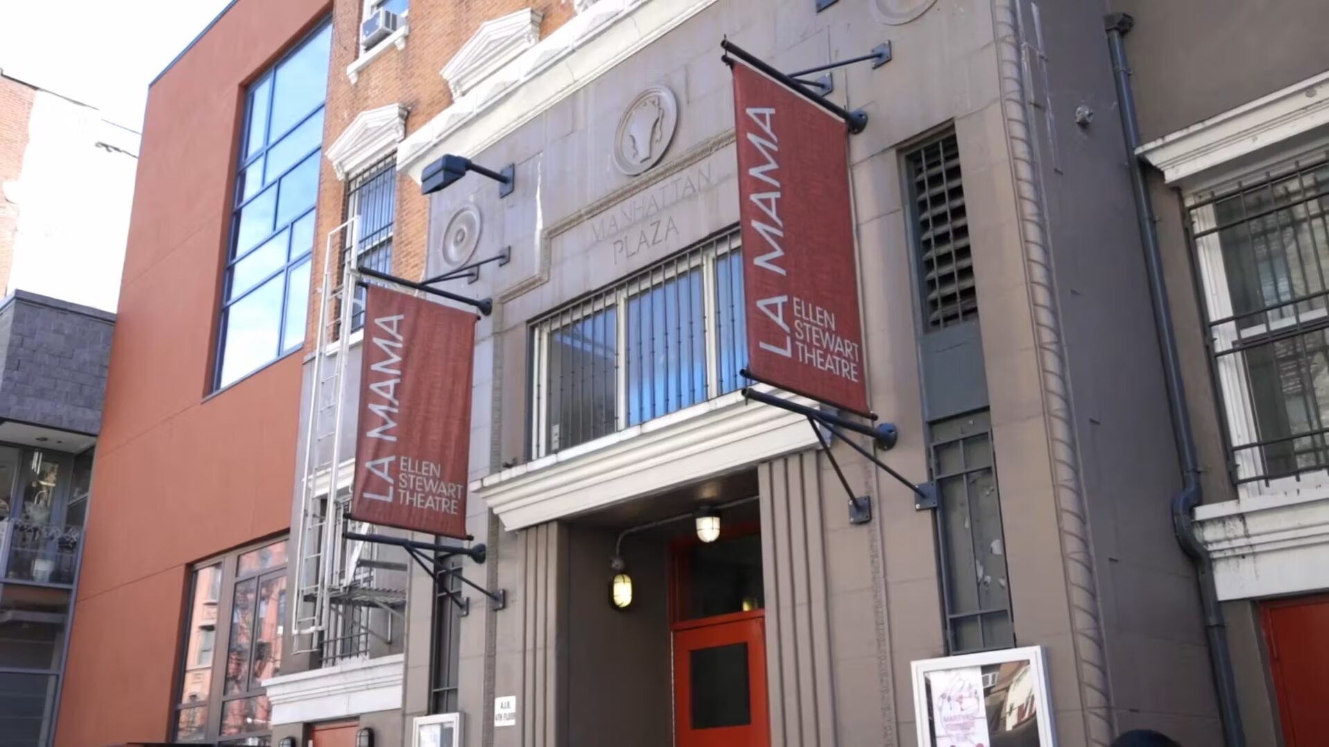 The entrance to a building with red banners.