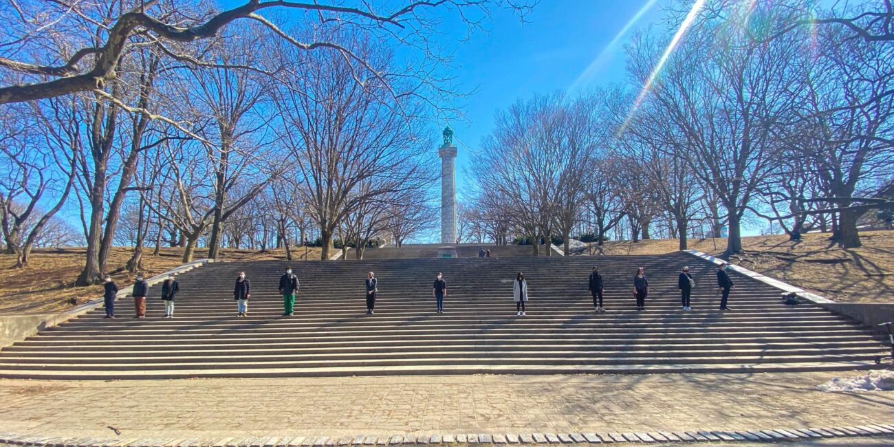 A group of people standing on steps in a park.