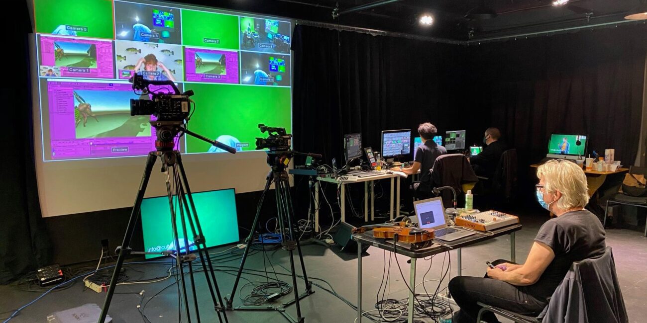 A group of people sitting in front of a green screen.