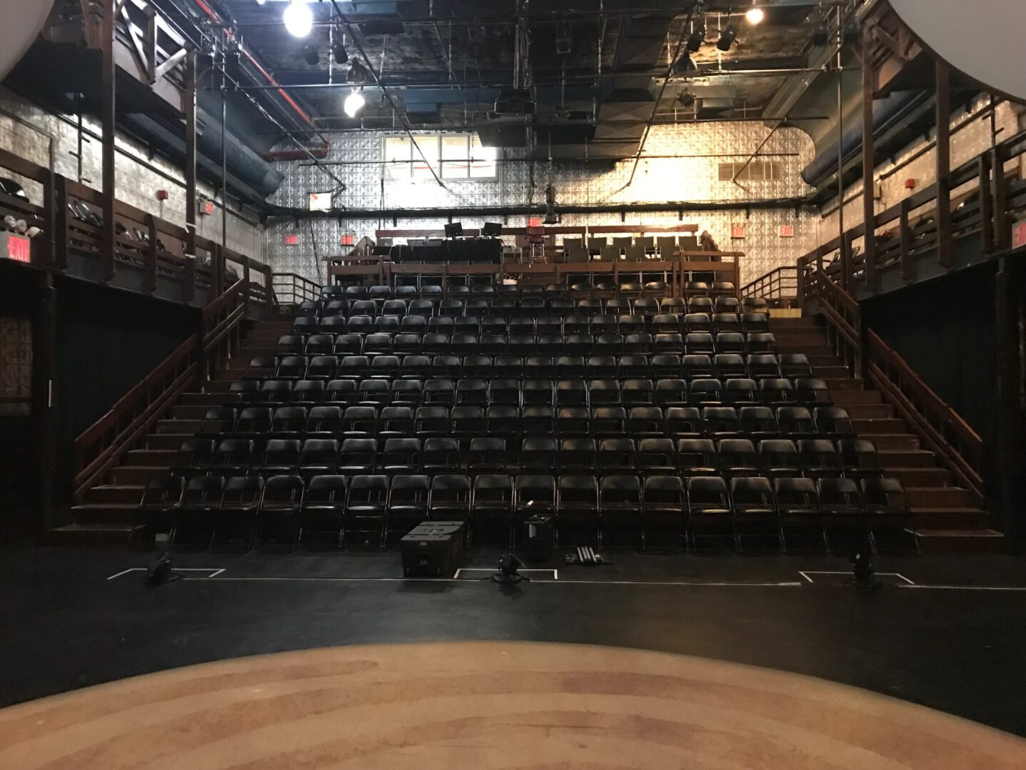 The stage of a theatre with a lot of empty seats.