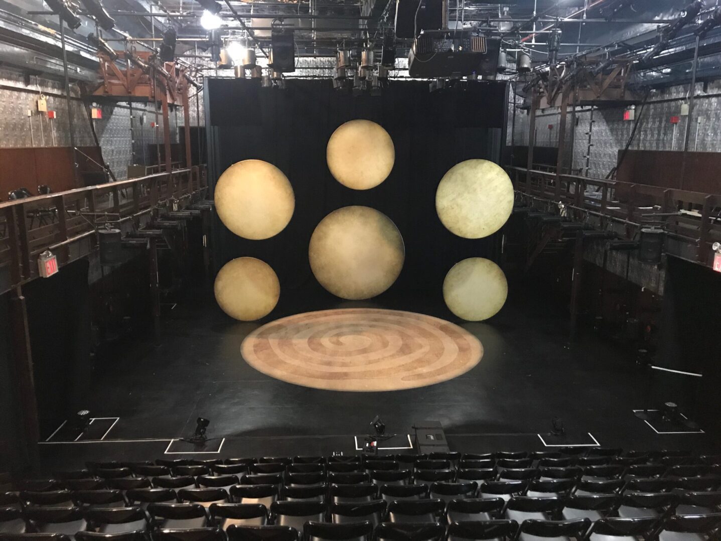 The stage of a theater with several circular lights on it.