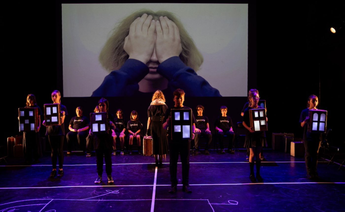 Theater performance with children holding windows.