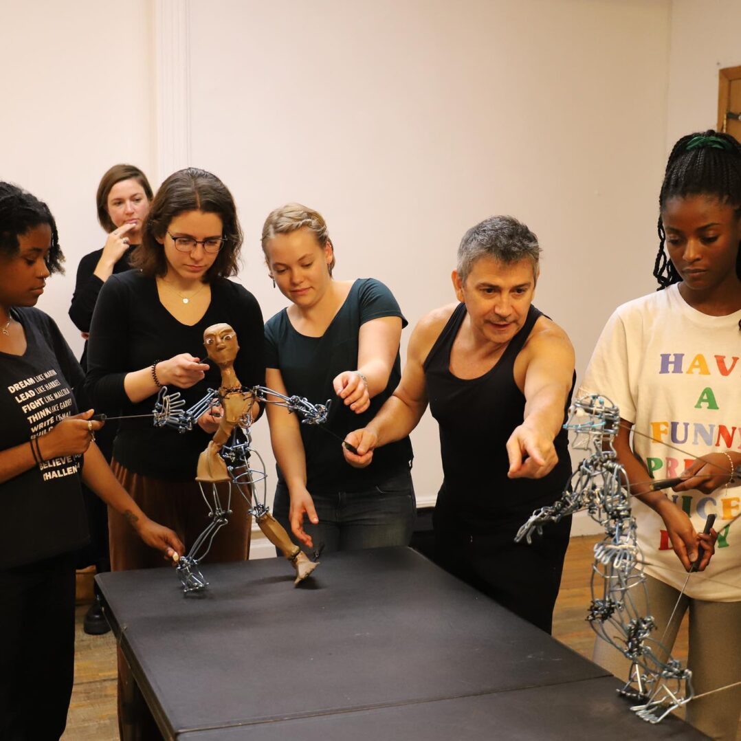 A group of people standing around a table with metal sculptures.