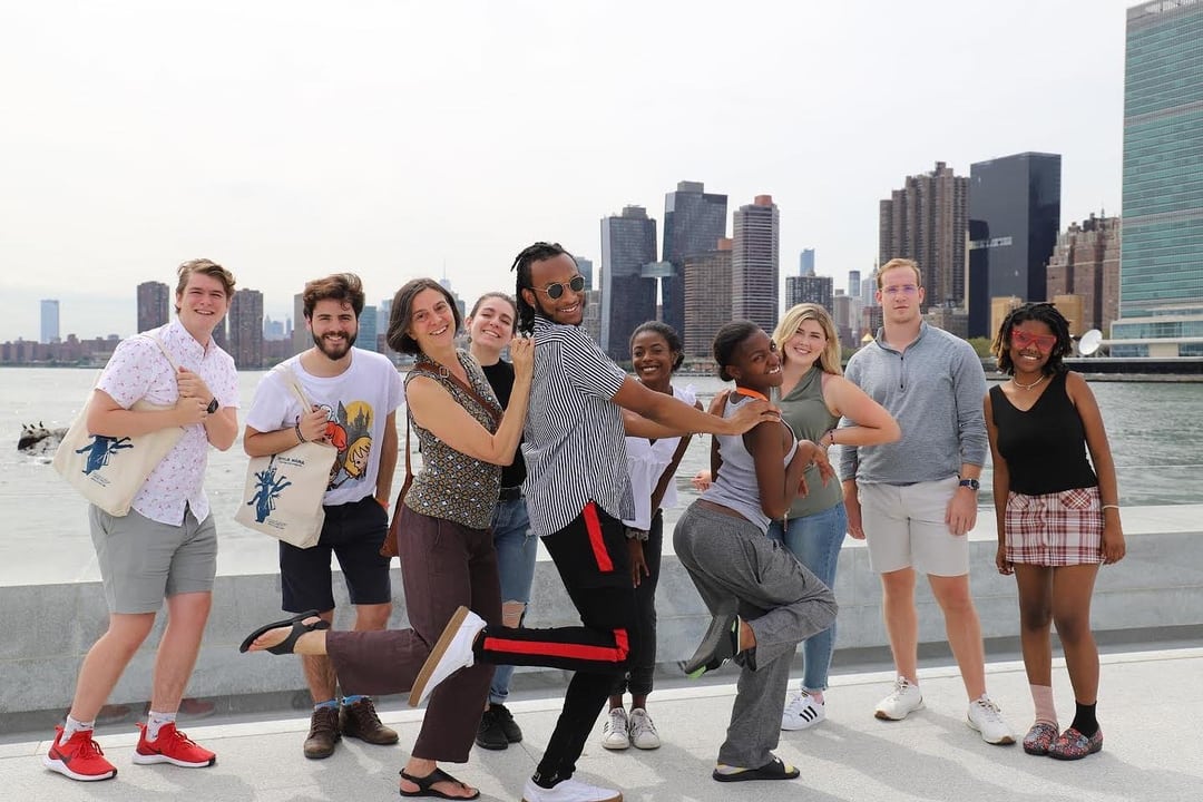 A group of people posing for a photo in front of a city.