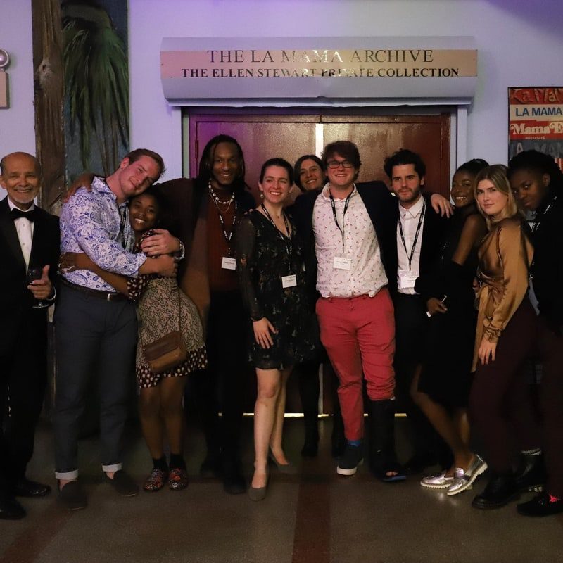 A group of people posing for a picture in front of a door.