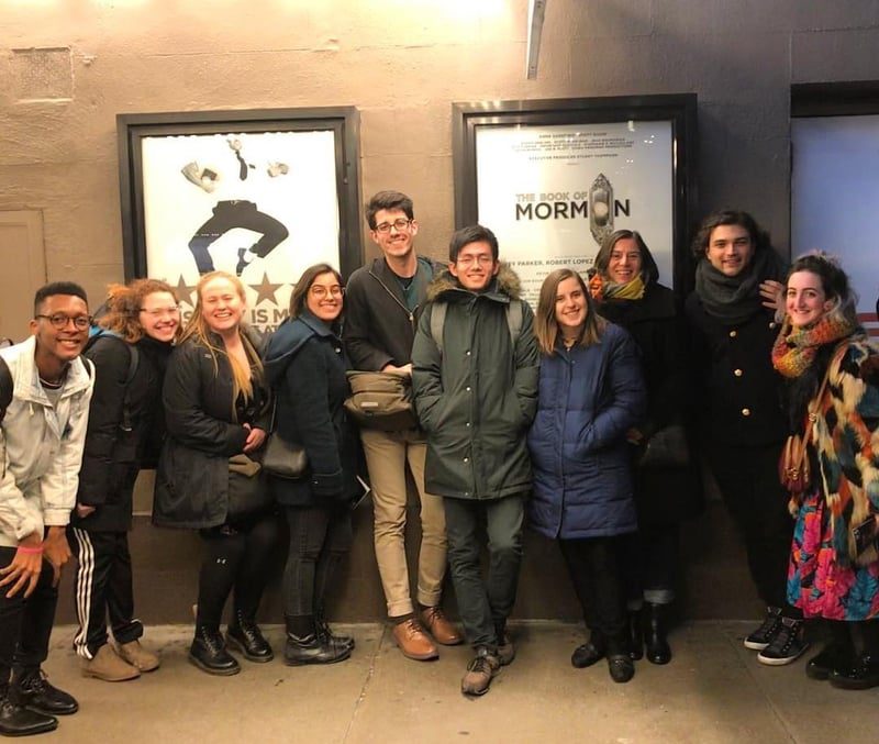 A group of people posing in front of a poster.