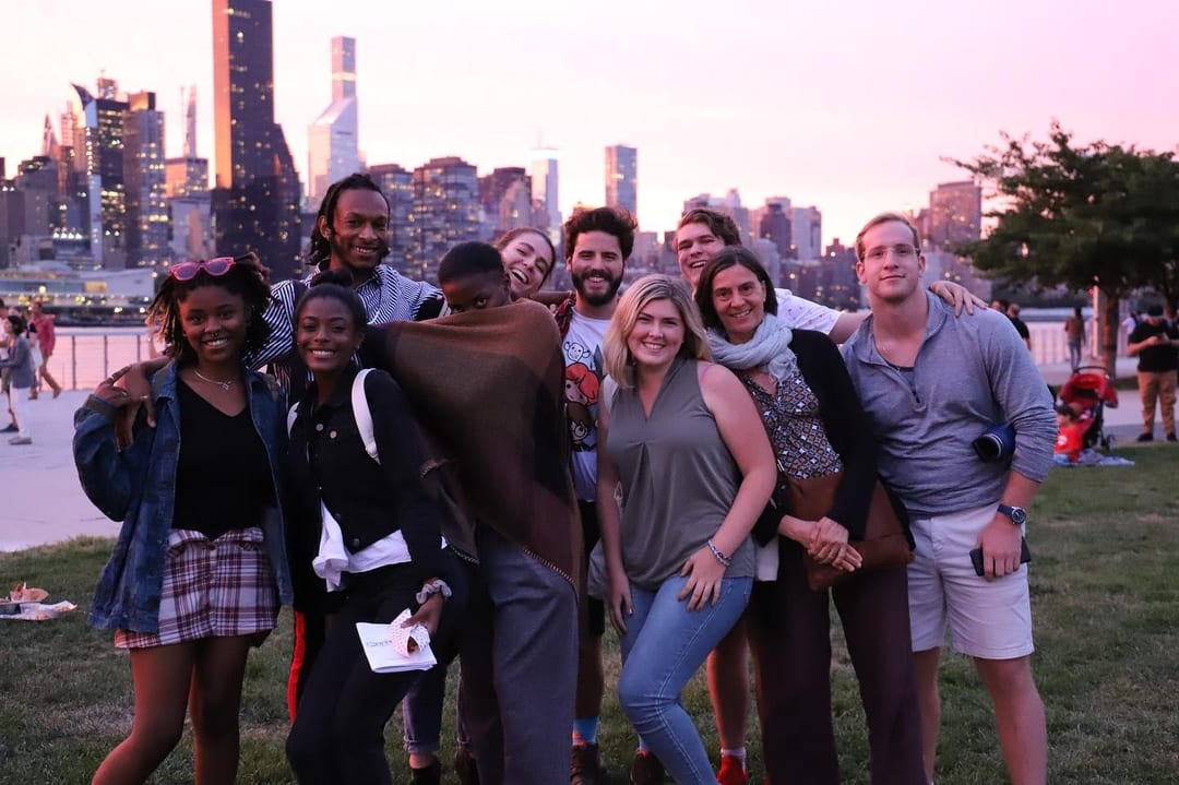 A group of people posing in front of a city skyline.