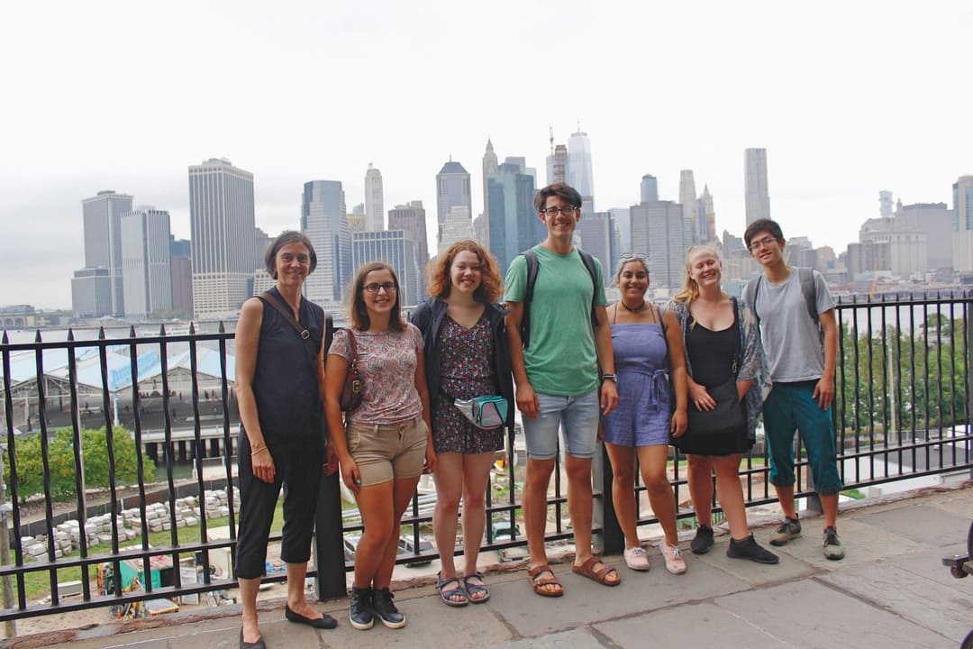 A group of people posing for a photo in front of a city skyline.