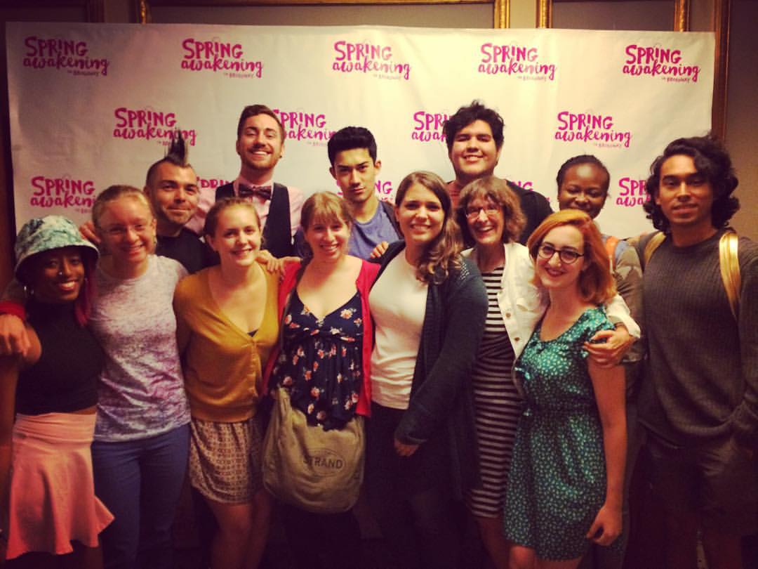 A group of people posing for a picture in front of a sign.