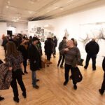 A group of people standing in an art gallery.