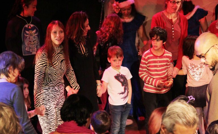 A group of people standing around a christmas tree.