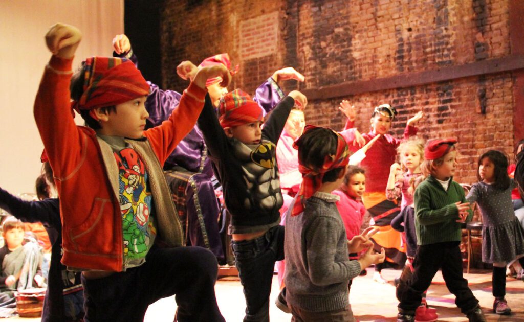 A group of children are dancing on a stage.