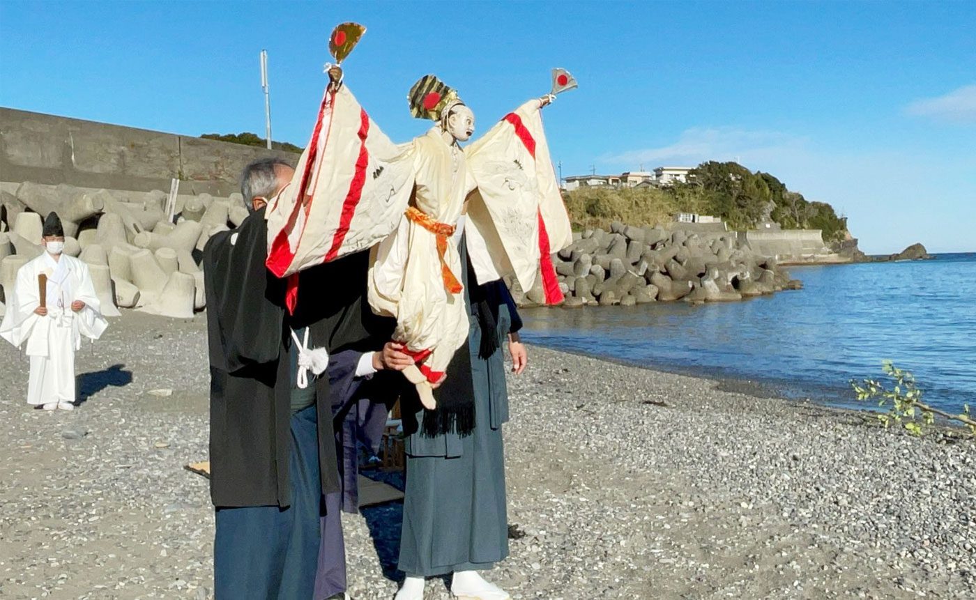 Traditional Japanese puppet performance on beach.