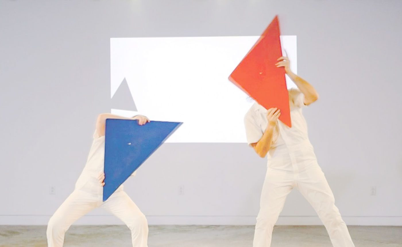 Two people holding colorful triangles.