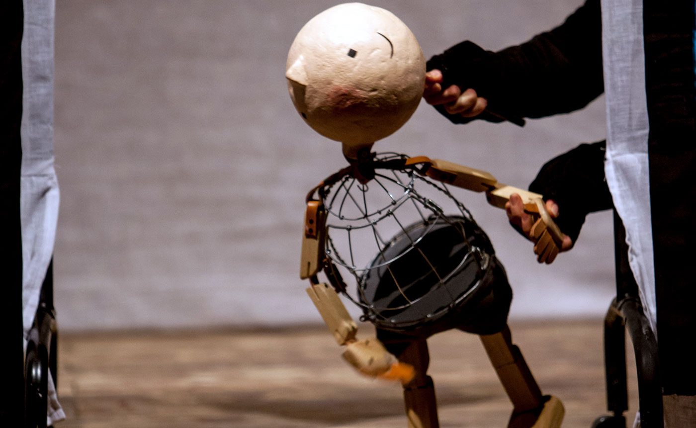 A puppet with a large head is being manipulated.