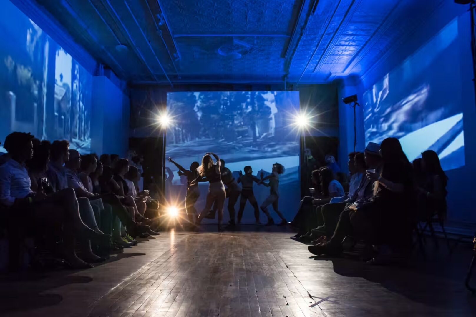 A group of people watching a fashion show on a stage.