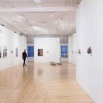 An art gallery with white walls and wooden floors.