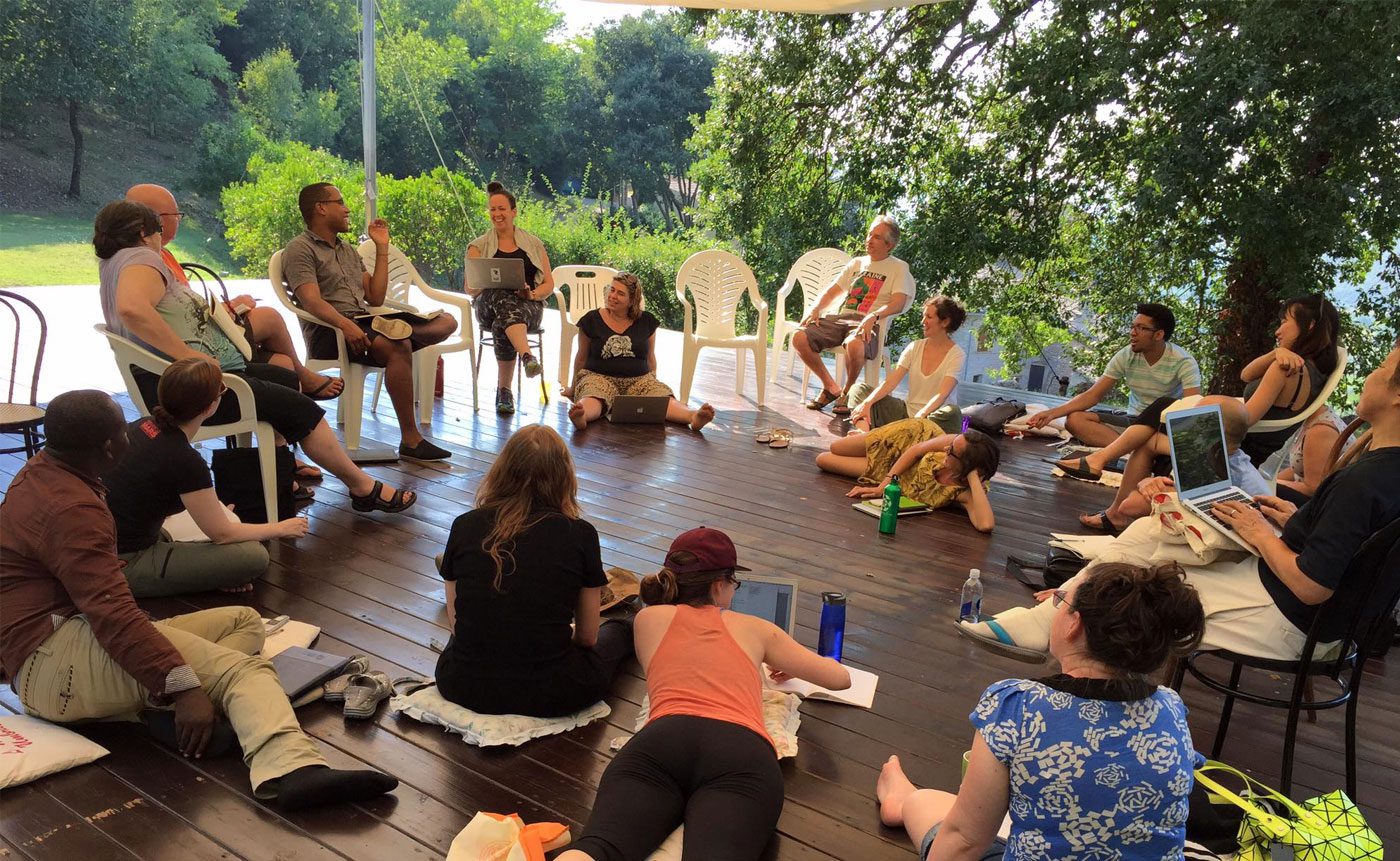 A group of people sitting on a wooden deck.