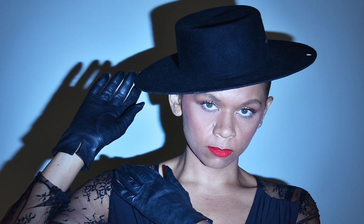 A woman wearing a black hat and gloves.