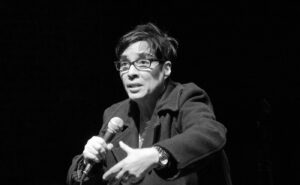 A black and white photo of a woman holding a microphone.