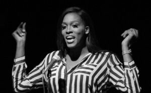 A black and white photo of a woman in a striped shirt.