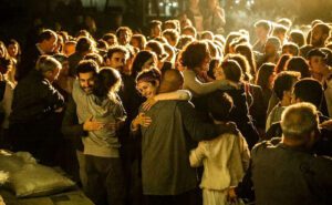 A crowd of people hugging in front of a building.