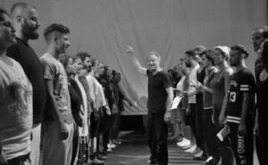 A black and white photo of a group of people standing in a line.