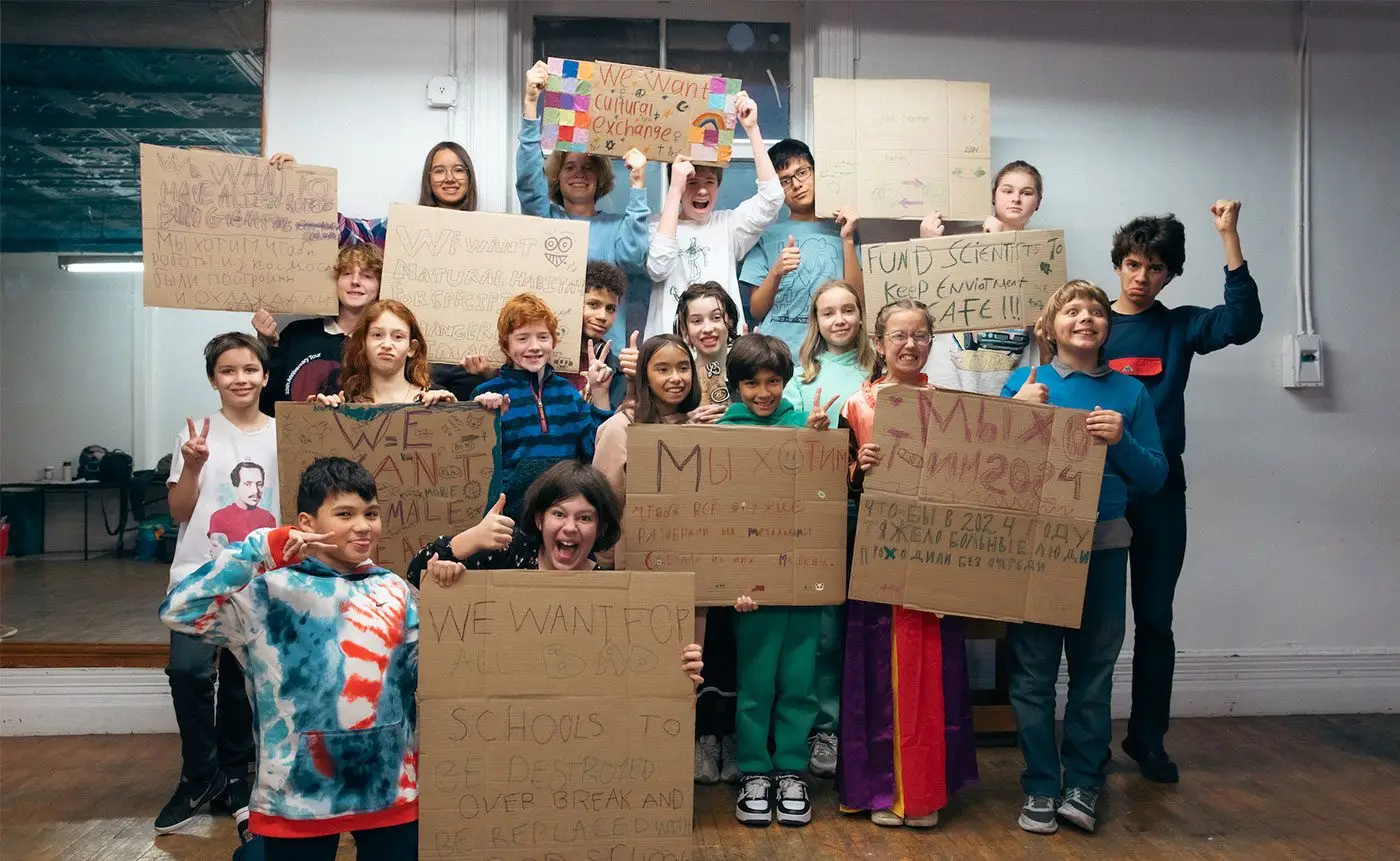 Group of children holding protest signs with various messages advocating for environmental and educational changes.