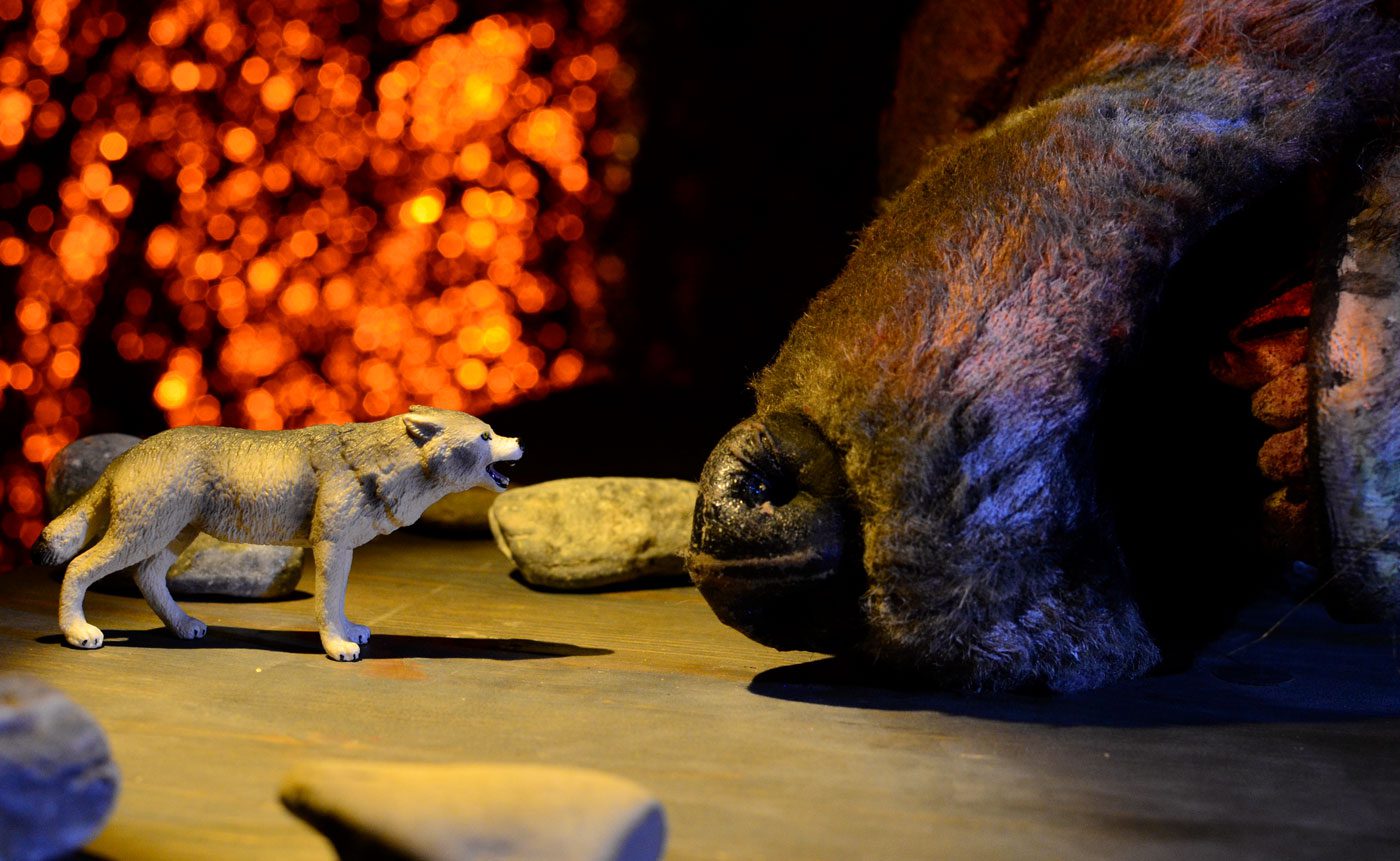 Wolf figurine facing a large plush toy.