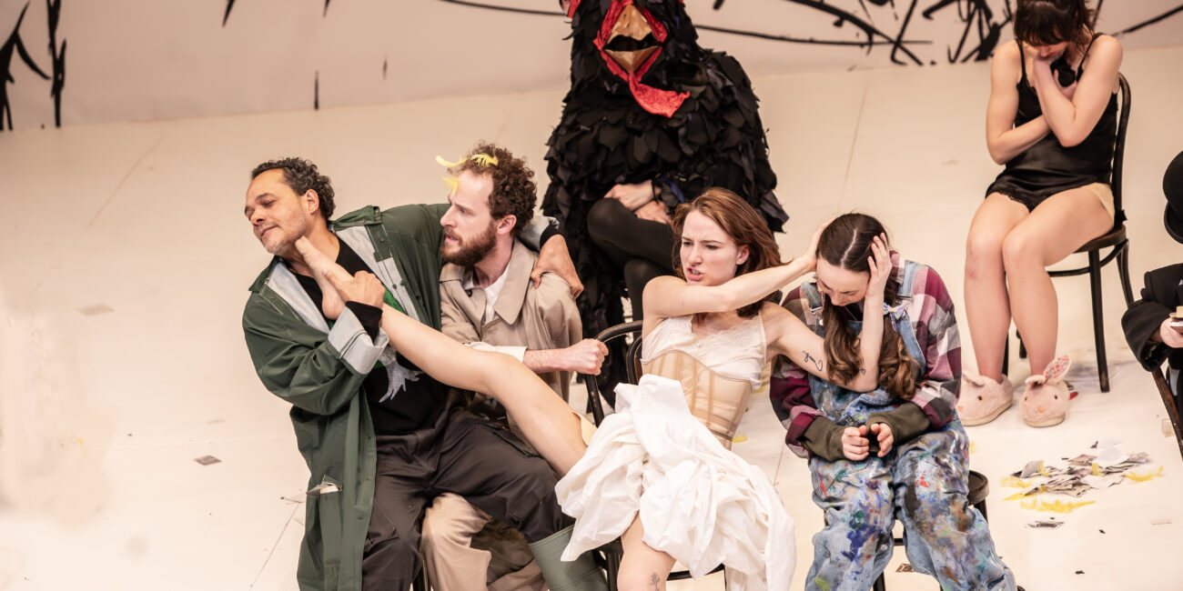 Actors in the middle of a performance while sitting in chairs
