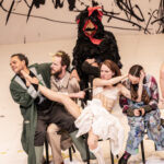 Actors in the middle of a performance while sitting in chairs